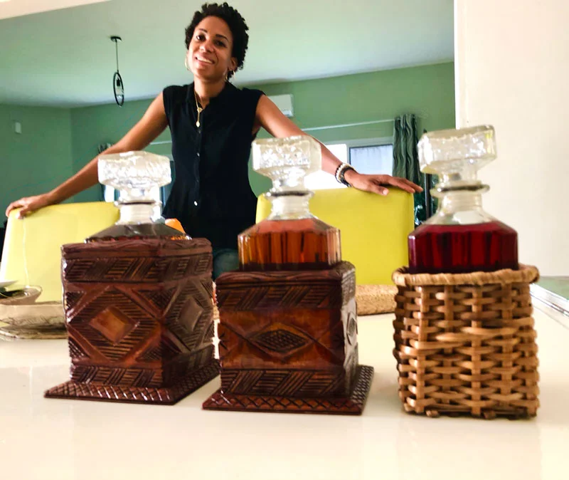 Femme souriante près de trois carafes décoratives